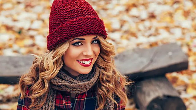 A woman wearing a knitted hat smiling