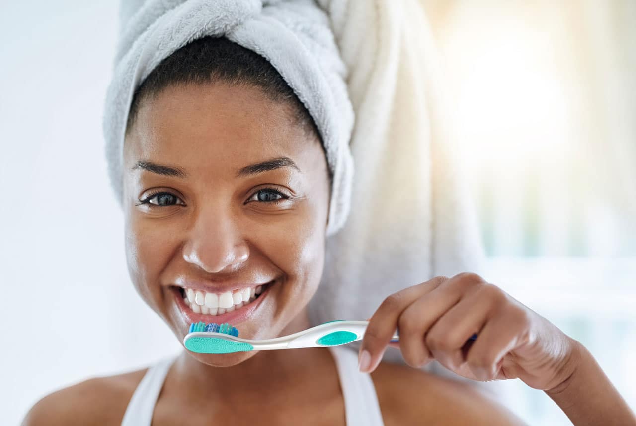 Young girl smiling while holding her toothbrush ready to brush her teeth