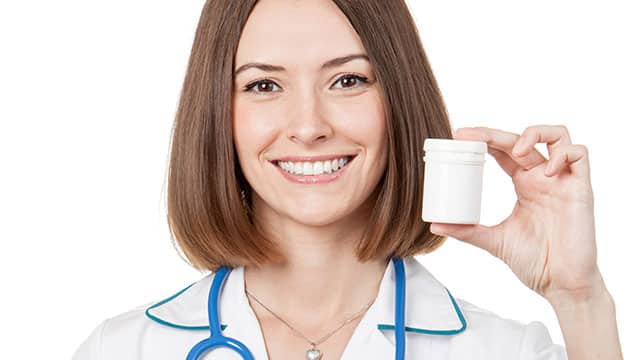 A female medical worker is holding a pill bottle