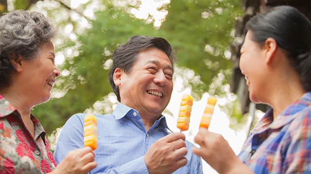 An middle age man and two women enjoy snacks