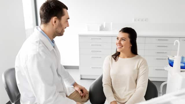 Female patient talking with a male dentist