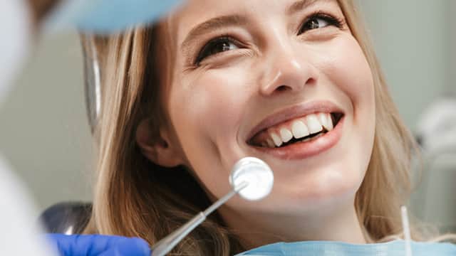 Smiling woman sitting in dental chair about to have an exam