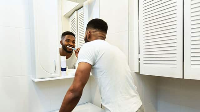 A man brushing his teeth in a bathroom