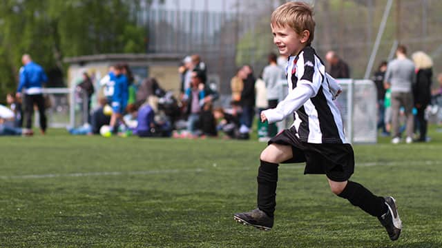 Boy playing soccer in a sunny weather