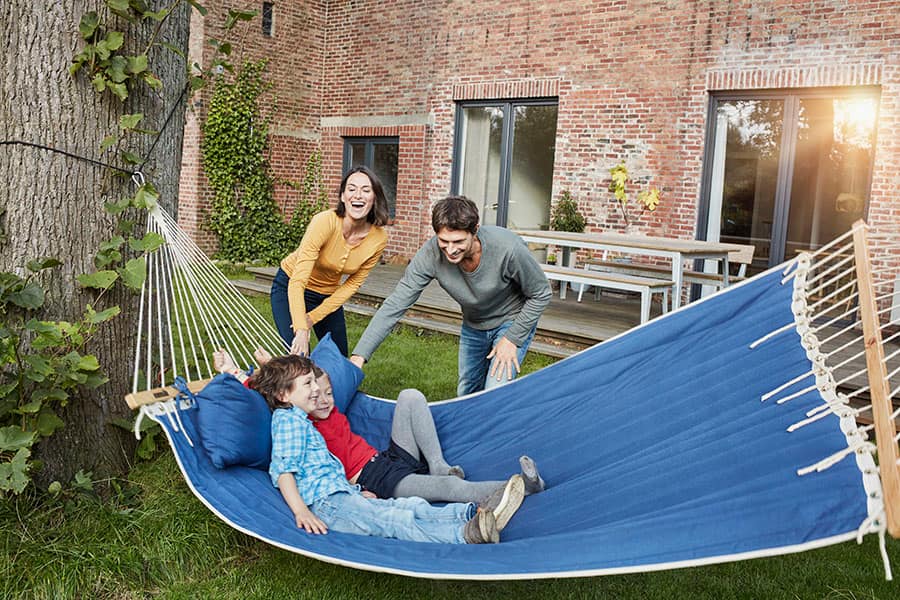 Happy family smiling and playing in a hammock