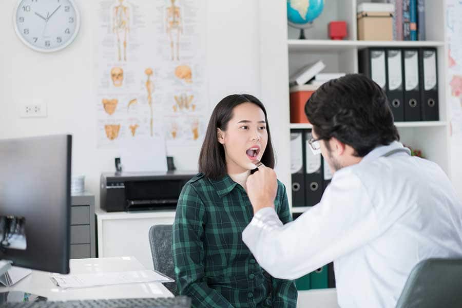 Doctor examining the patient's oral cavity in his dental office
