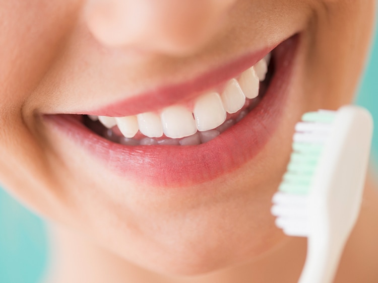 close up of smiling mouth with colgate toothbrush