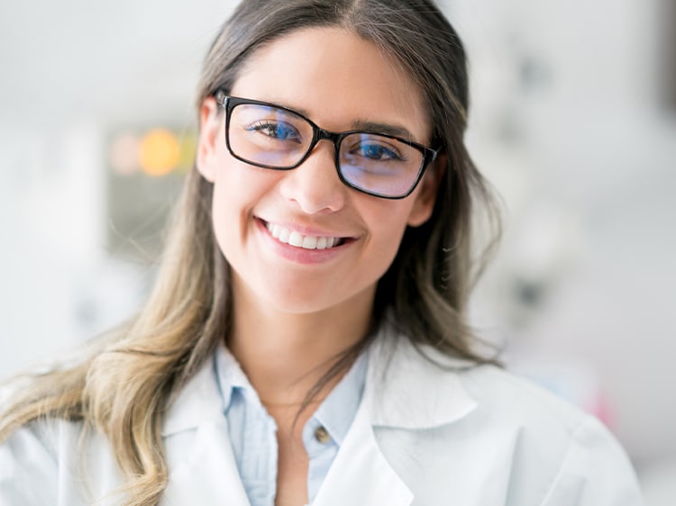 smiling woman wearing glasses showing white teeth