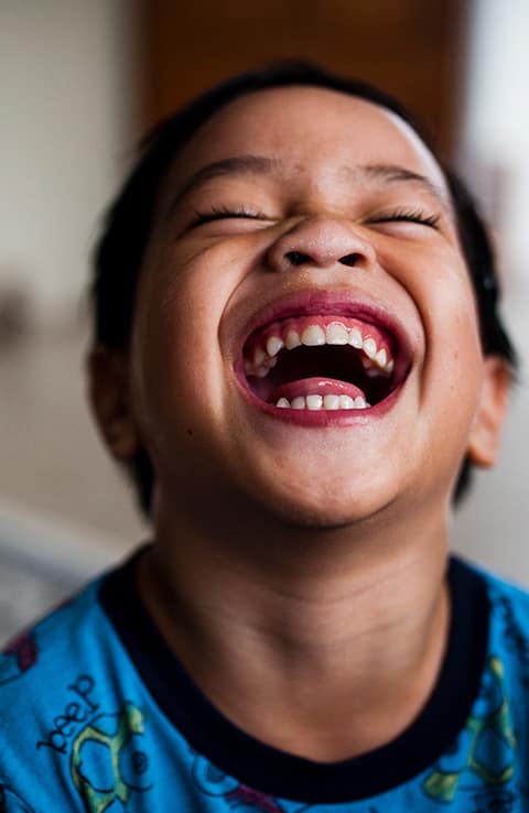 toddler laughing and showing teeth 