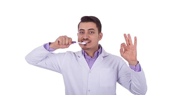 Dentist showing how to brush teeth properly