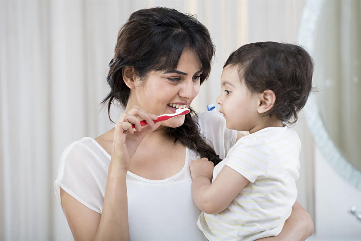 Mom brushing her teeth with her child