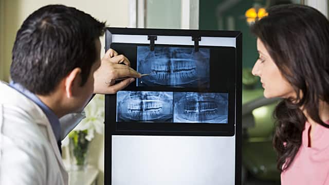 dentist showing dental x-ray to the assistant