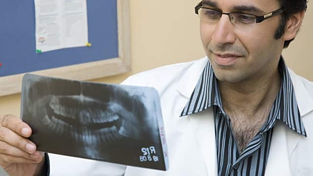 dentist inspecting dental x-ray