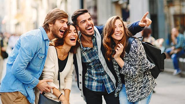 A group of friends hugging and laughing on the street