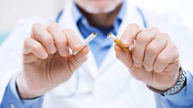 A close-up of doctor's hands breaking a cigarette