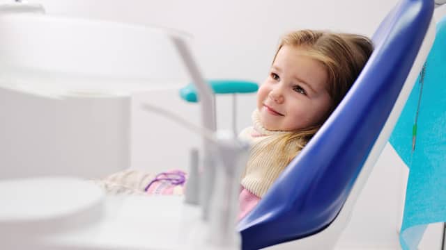 Young girl sitting in a dental chair waiting for a dental appointment