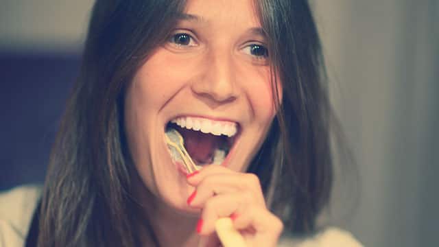 Young woman is brushing her teeth