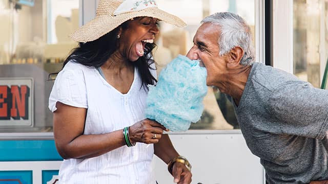 Senior couple laughing and eating cotton candy