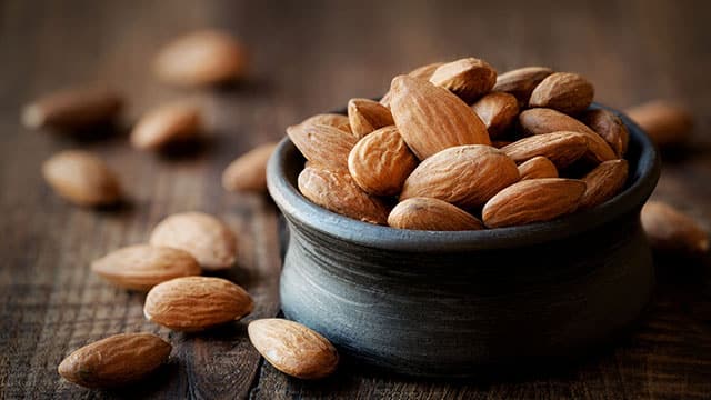 Almonds in black bowl that are good for your teeth
