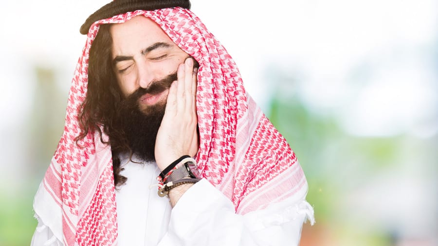 Arabian business man with long hair wearing traditional keffiyeh scarf touching mouth with hand