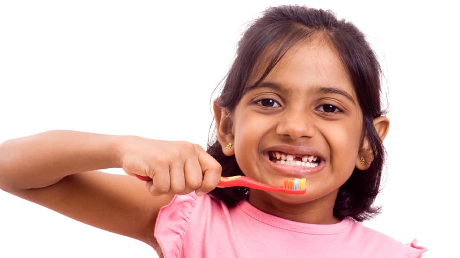 Cute girl brushing teeth with kid toothbrush