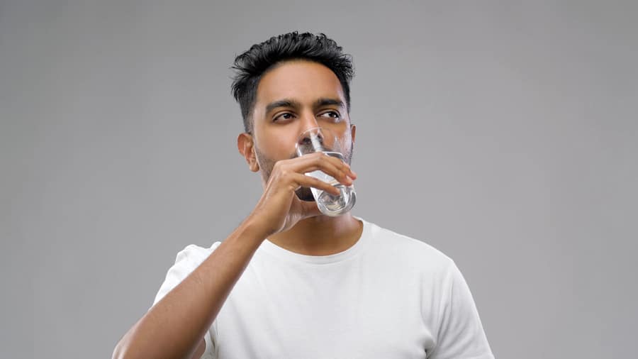 Man drinking water to alleviate potential side effects of chemotherapy