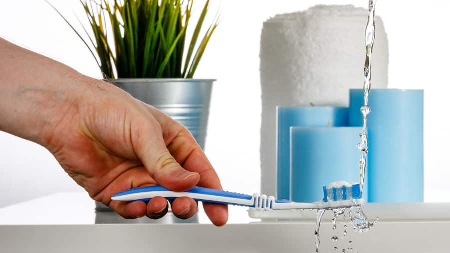 Clean the toothbrush by water