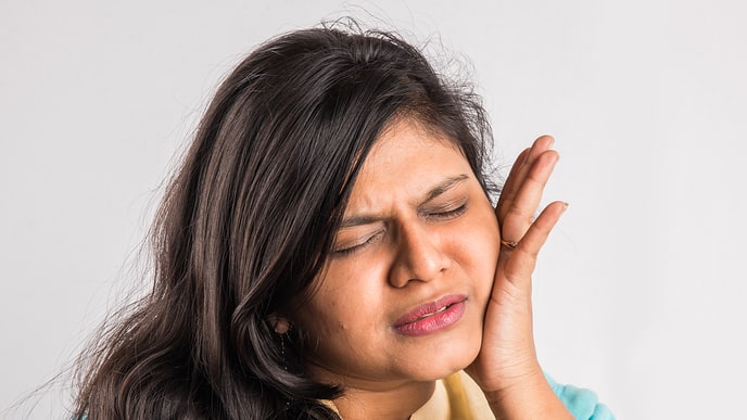 A woman in pain seeking tooth pain relief options