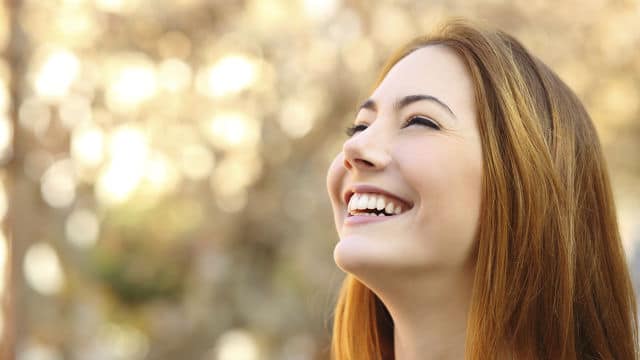  a young girl is smiling outdoors