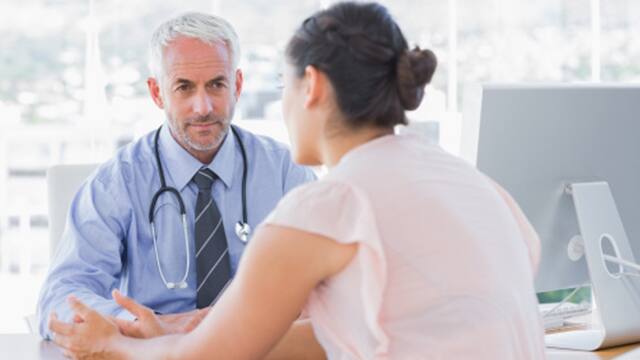 A female patient talking to her dentist in the office