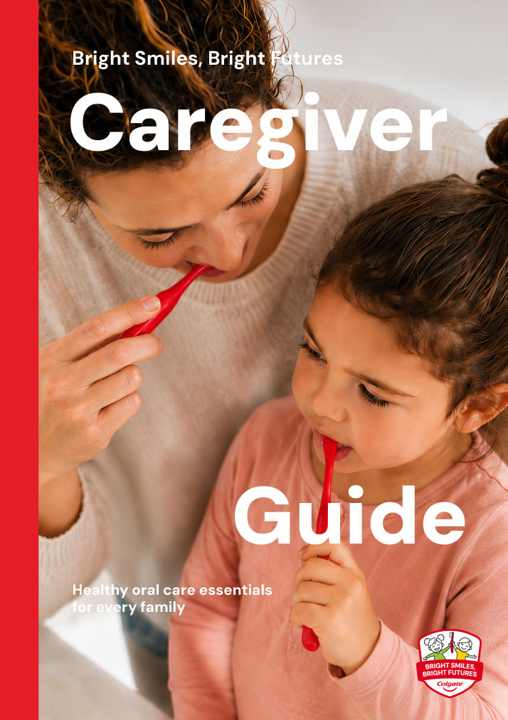 Cover of the Colgate Bright Smiles, Bright Futures Caregiver Guide showing a mother helping her young daughter brush her teeth at home.