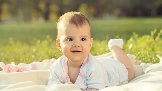 Smiling infant lying on its stomach
