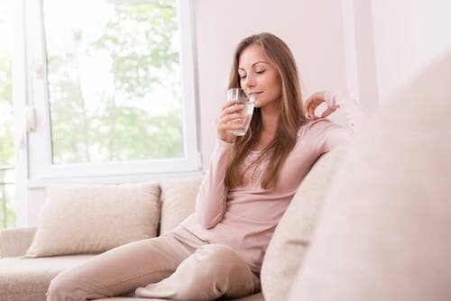 woman drinking water to aid her submandibular gland swelling