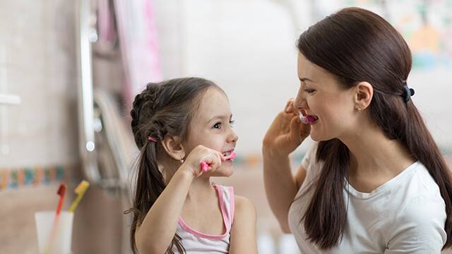 madre e hija lavandose los dientes