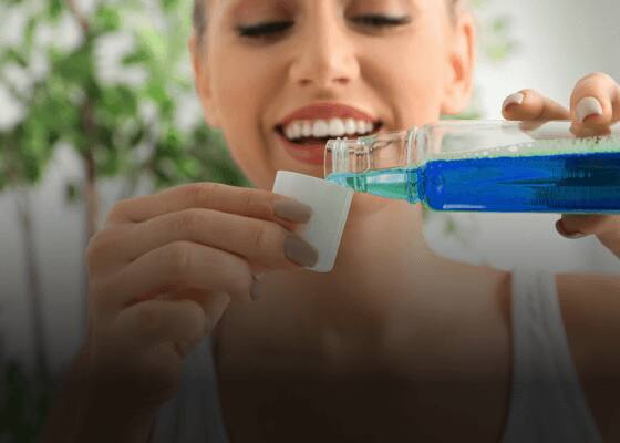 Girl using mouthwash for improved oral health and fresh breath
