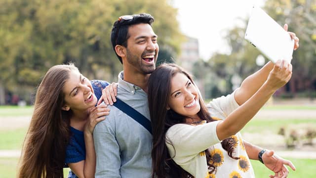 Three happy friends taking a photo