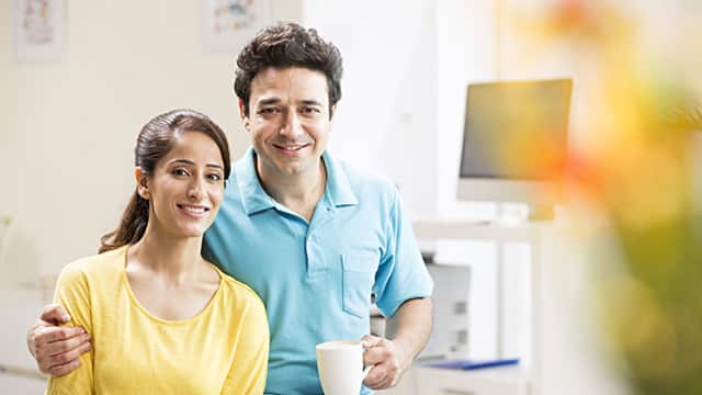 Couple looking at the camera with a cup of coffee