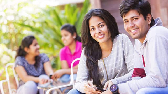 a man and a woman smiling while sitting down outdoor