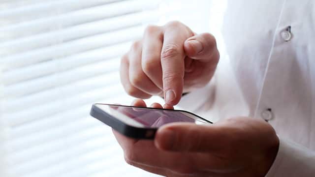 Close up of the man's hands using a smartphone