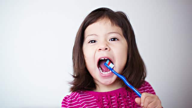 Kid brushing her teeth