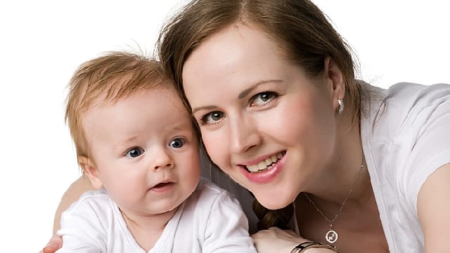 A mother smiling and a baby