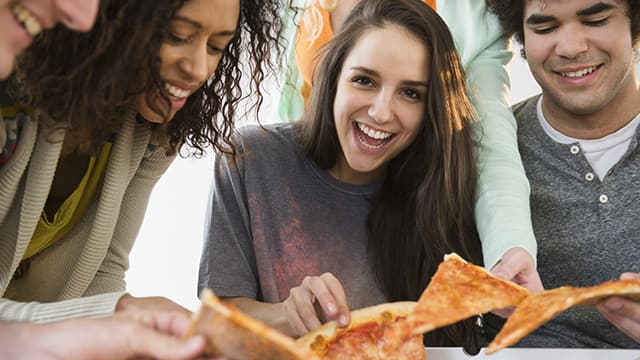 Amigos comiendo pizza juntos