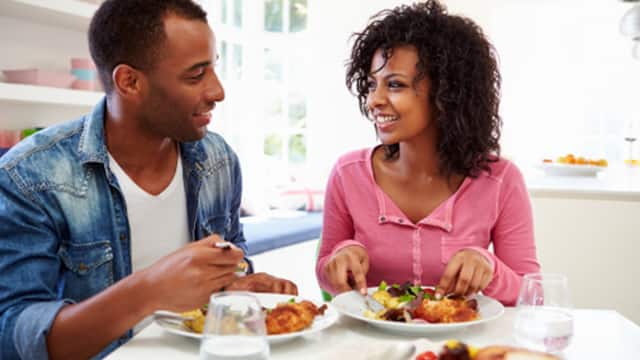 Pareja sonriendo y comiendo