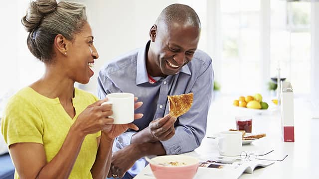 Pareja desayunando y riendo