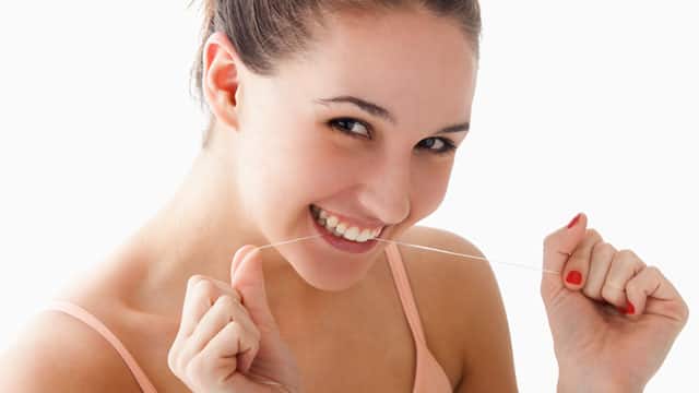 Mujer usando hilo dental