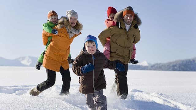 Parents are playing with their kids in a snow