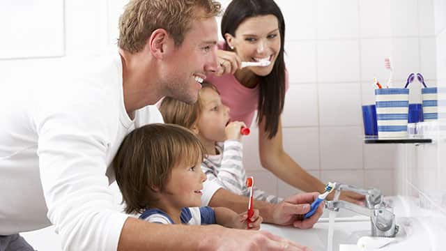 Familia cepillandose los dientes