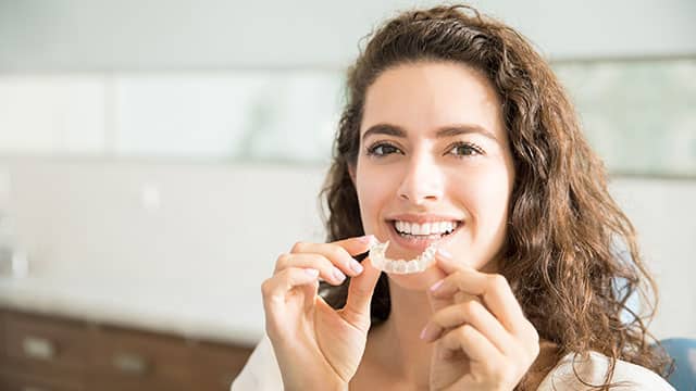 Patient Holding Orthodontic Retainers In Dental Clinic