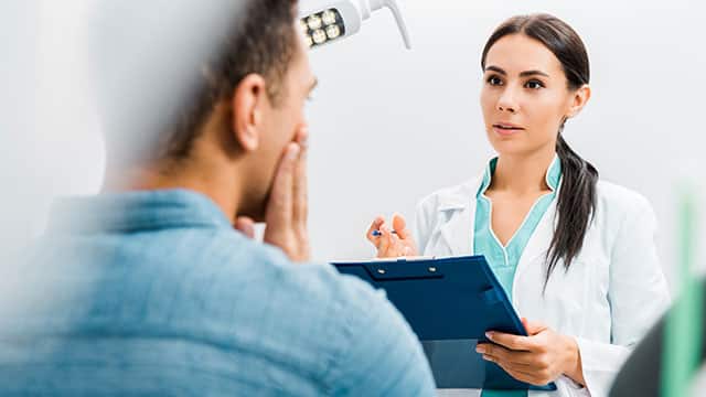 patient talking to dentist in dental office.