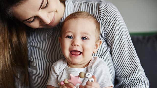 A woman holding a smiling baby